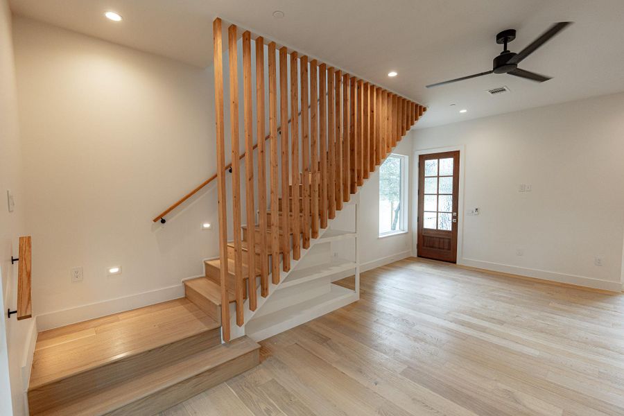 Clean lines and a modern wooden staircase define this inviting entryway with warm hardwood floors. Clean lines and a modern wooden staircase define this inviting entryway with warm hardwood floors.