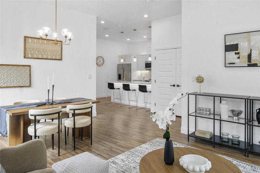 Living room with light wood-style floors, a chandelier, and recessed lighting Living room with light wood-style floors, a chandelier, and recessed lighting