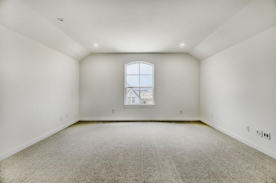 Unfurnished room featuring lofted ceiling, light carpet, and recessed lighting