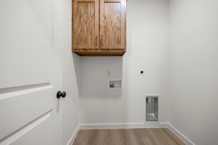 Functional laundry room featuring sturdy wood cabinetry and durable flooring for daily tasks. Functional laundry room featuring sturdy wood cabinetry and durable flooring for daily tasks.