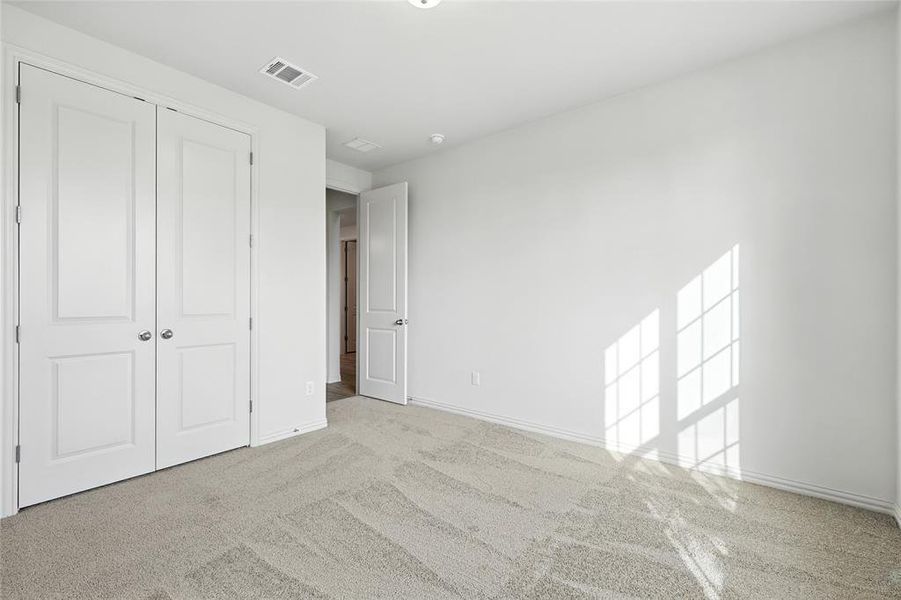 Unfurnished bedroom with carpet flooring and a closet