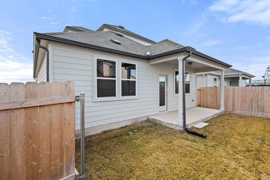Rear view of house with a patio and roof with shingles