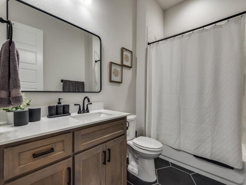 Full bathroom with vanity, toilet, shower / bathtub combination with curtain, and tile patterned flooring