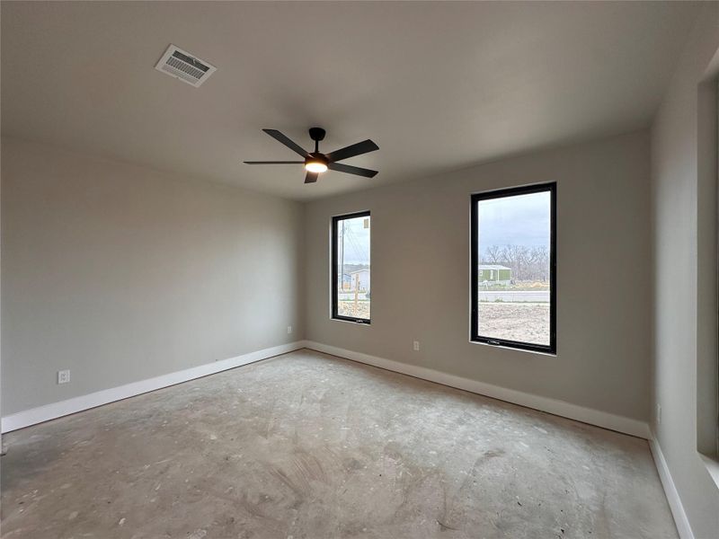 Spare room with ceiling fan and unfinished concrete floors