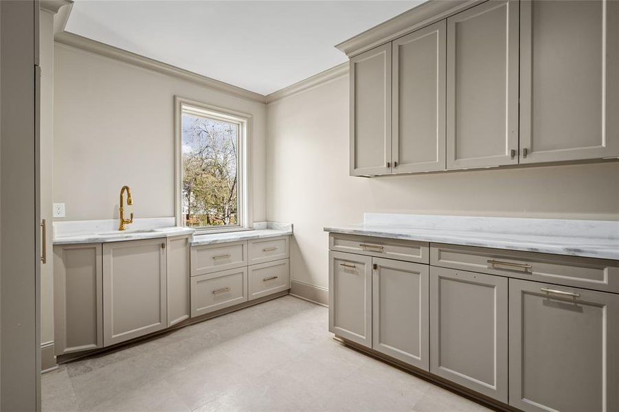 Laundry rooms on both floors add wonderful convenience to the home. This second-floor laundry room features a sink with a pull-down faucet and abundant storage space for cleaning supplies.