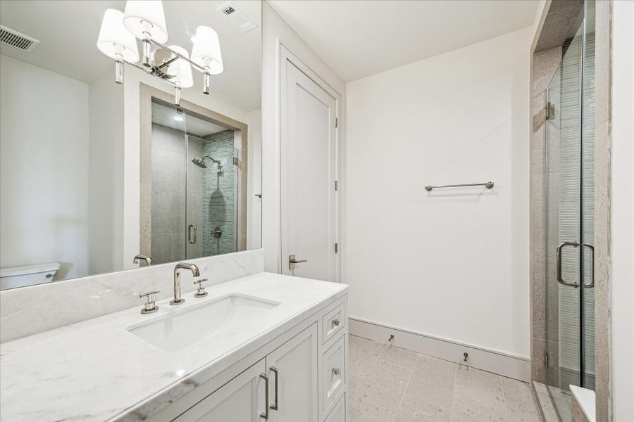 Each secondary, en-suite bathroom features custom-built cabinetry, marble counters, Brizo Litze polished nickel fixtures, and a unique tile design.