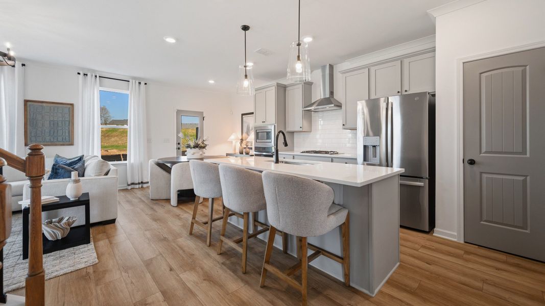 Kitchen with pendant lighting, tile backsplash, and quartz countertops Kitchen with pendant lighting, tile backsplash, and quartz countertops