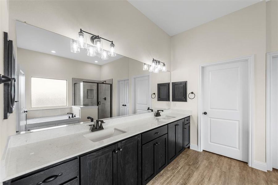 Bathroom featuring a dual vanity with dark wood-finish cabinetry, light-colored countertops, and undermount sinks