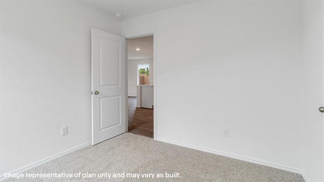 Carpeted spare room featuring baseboards