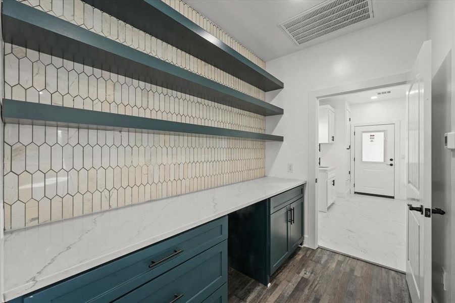 Kitchen with dark wood-type flooring and light stone countertops