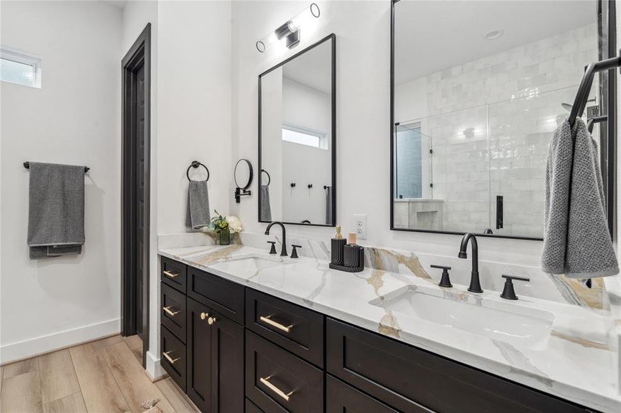 The double vanity with luxurious quartz countertops and elegant black fixtures creates a sophisticated yet practical space in this primary bathroom.