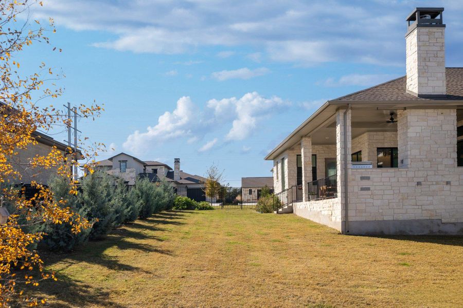 A flat backyard offers room to roam, play, or personalize, framed by Hill Country surroundings.