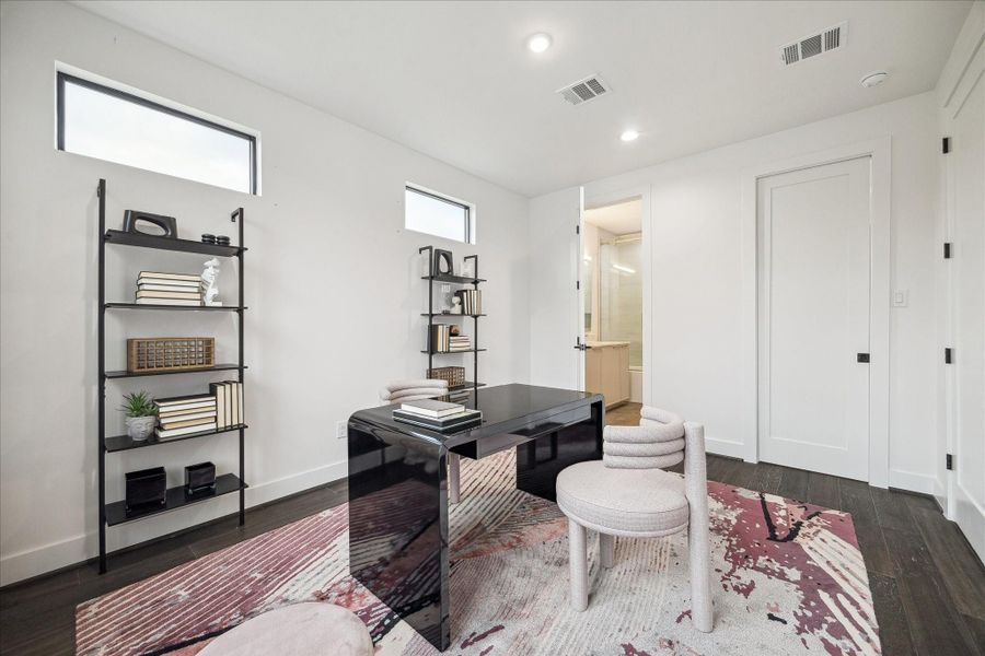 First-floor home office provides flexible living with abundant natural light, wide-plank flooring, and direct access to a full en-suite bath. Ideal for guests, remote work, or multigenerational living, this versatile space reflects the home’s thoughtful 3-bedroom, 3.5-bath layout designed for modern lifestyles.