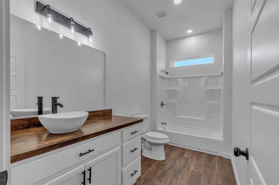 Full bathroom featuring  shower combination, hardwood / wood-style flooring, vanity, and toilet