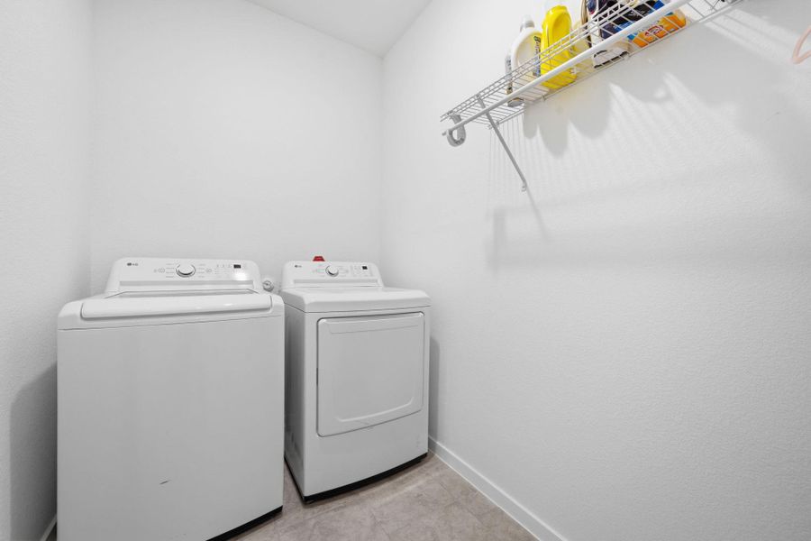 Laundry area featuring separate washer and dryer and baseboards