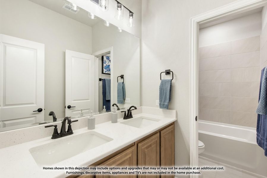 Bathroom with double sink vanity, wood cabinets, white countertop, large mirror, and tiled shower-tub combo Bathroom with double sink vanity, wood cabinets, white countertop, large mirror, and tiled shower-tub combo