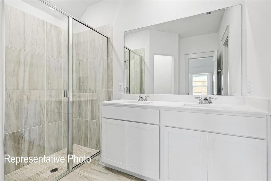 Bathroom featuring a dual vanity with white cabinetry, integrated sinks, and chrome fixtures