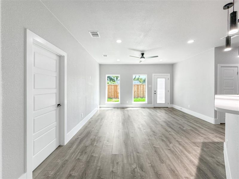 Unfurnished living room with light wood-style floors, ceiling fan, recessed lighting, and a textured ceiling