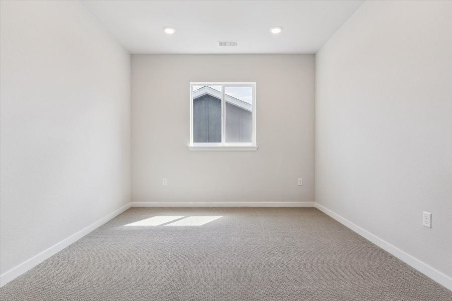 A room with a window and a carpet.
