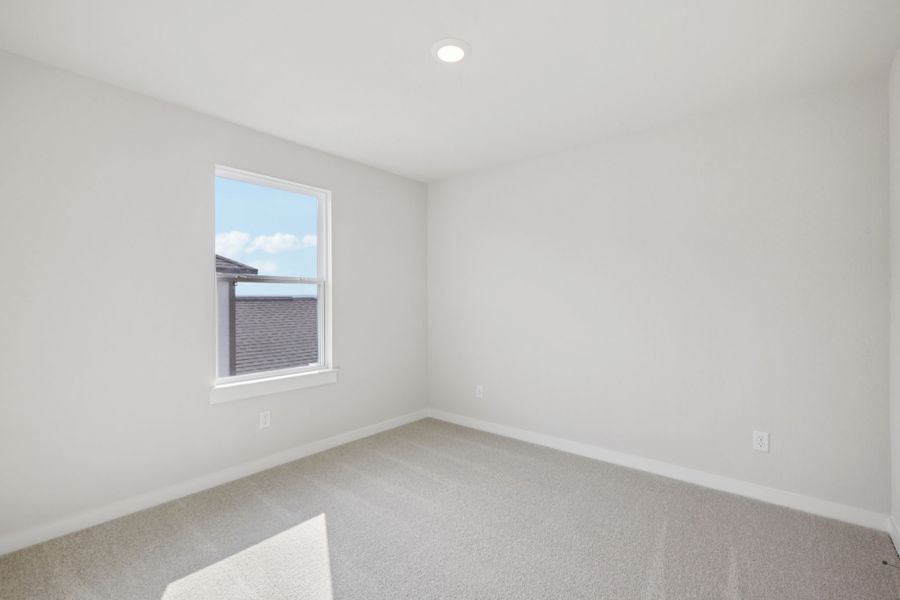 A room with a window and a rug.