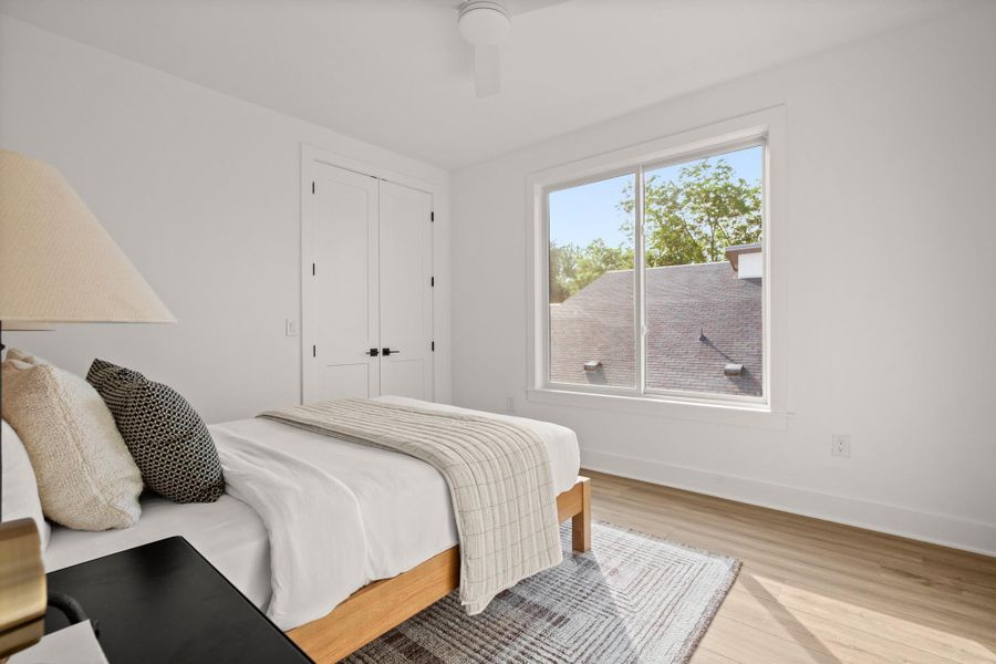 Bedroom featuring a closet, ceiling fan, baseboards, and wood finished floors