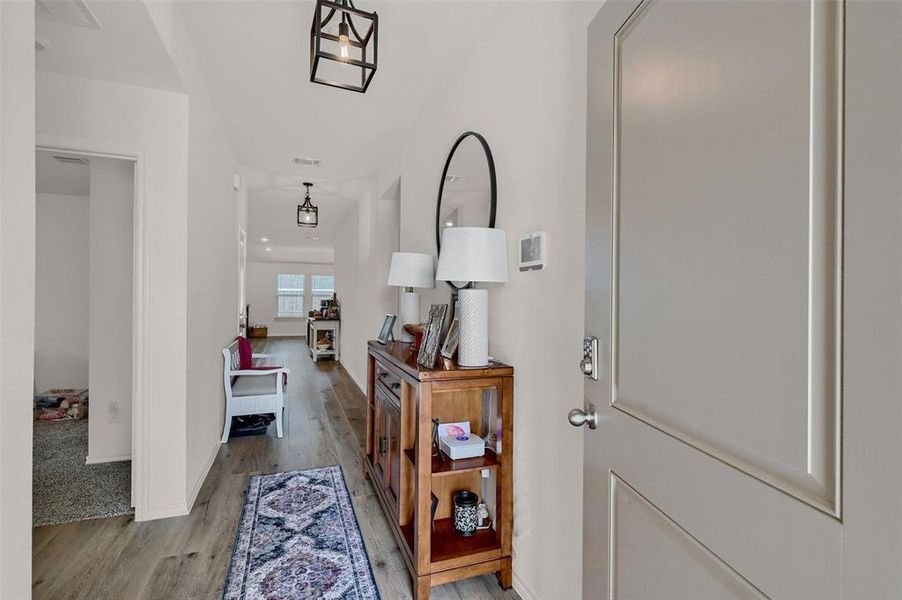 Entryway with baseboards, light wood-type flooring, and visible vents