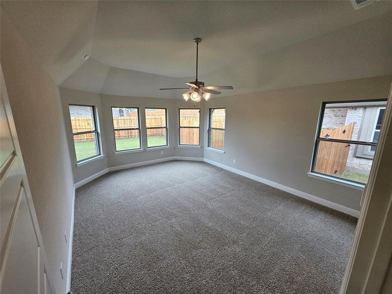 Master bedroom with bay window, vaulted ceiling, and ceiling fan.