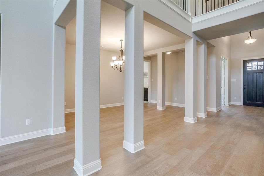 Foyer with light hardwood / wood-style floors and an inviting chandelier