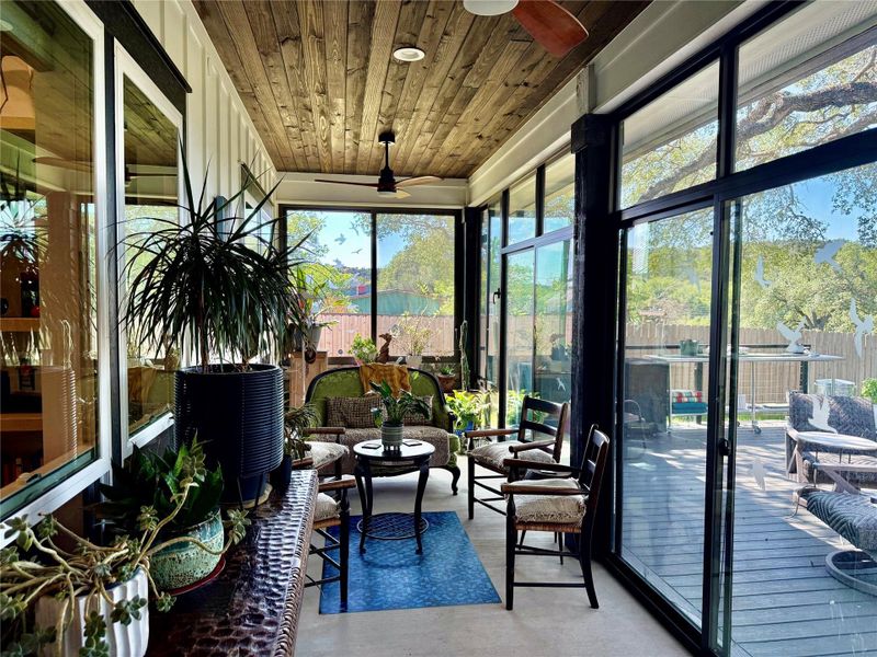 Glass Solarium porch featuring a wood-finish plank ceiling, multiple ceiling fans, and large pane windows