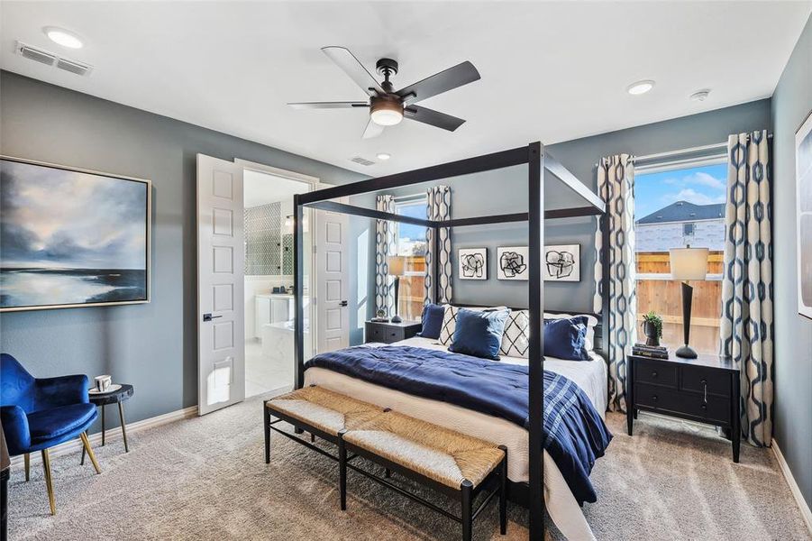 Carpeted bedroom featuring connected bathroom and ceiling fan