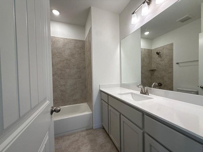 Bathroom with vanity, shower / bath combination, and recessed lighting