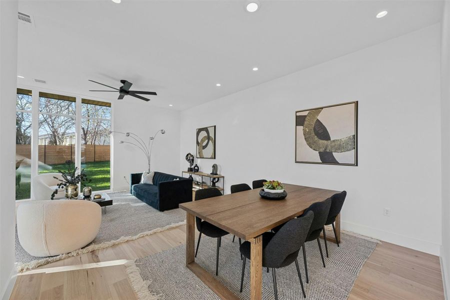 Dining space featuring recessed lighting, light wood finished floors, expansive windows, and ceiling fan Dining space featuring recessed lighting, light wood finished floors, expansive windows, and ceiling fan