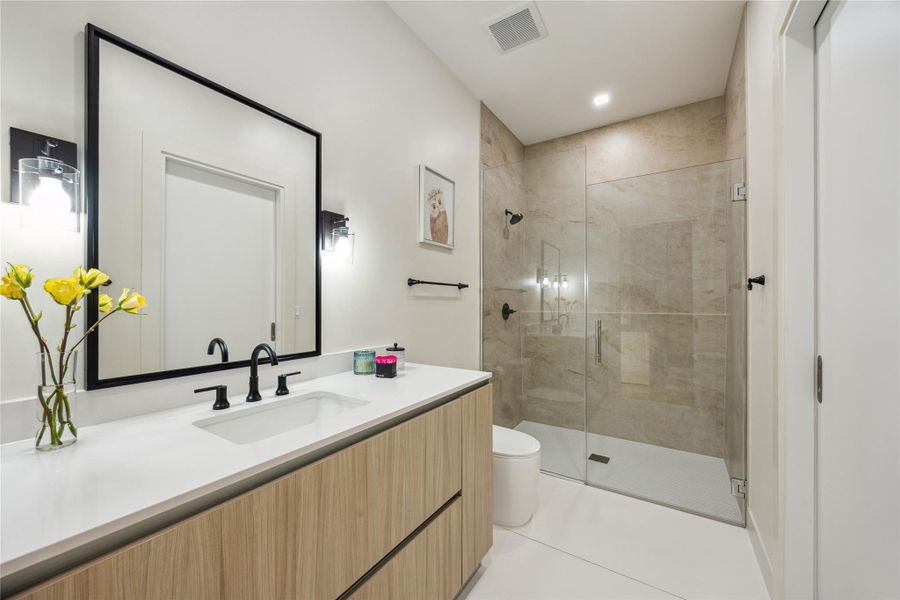 Secondary bath room features a vanity, Pedini cabinets and edgeless shower.