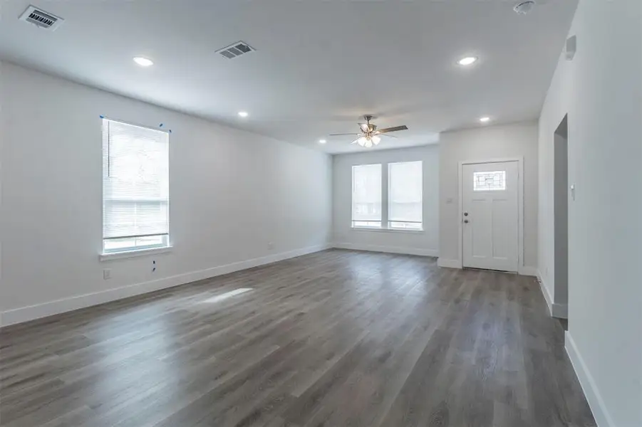Unfurnished living room with ceiling fan and dark hardwood / wood-style floors