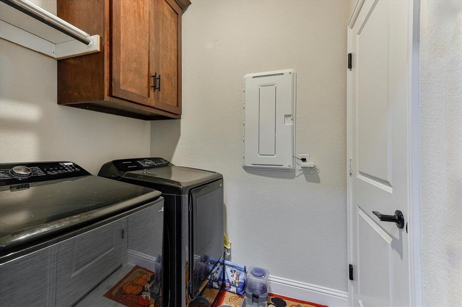 The laundry room features drying rod and shelf as well as cabinet space for storage The laundry room features drying rod and shelf as well as cabinet space for storage