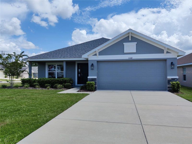 Front exterior of a new home in Sunset Landing, Spring Hill, FL, highlighting curb appeal (Image 20).