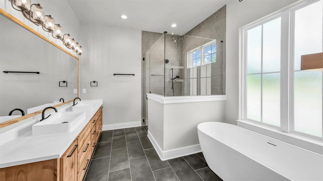 Modern bathroom featuring a freestanding soaking tub, a spacious glass-enclosed shower with tile surround, and a double vanity with rectangular vessel sinks