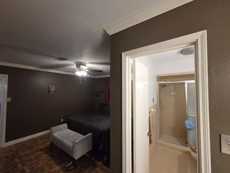 Bedroom with crown molding, a ceiling fan, and ensuite bath Bedroom with crown molding, a ceiling fan, and ensuite bath