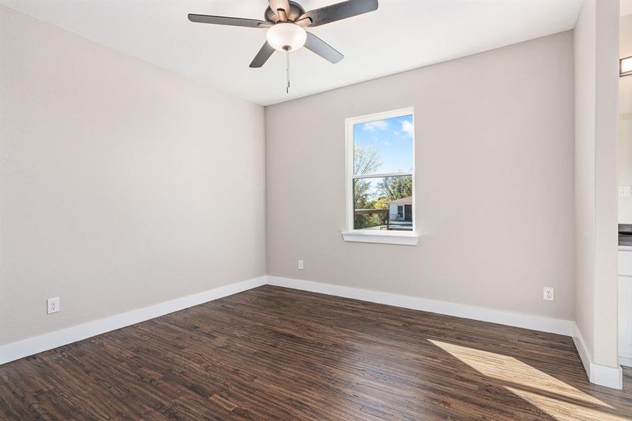 Unfurnished room with ceiling fan and dark wood-type flooring