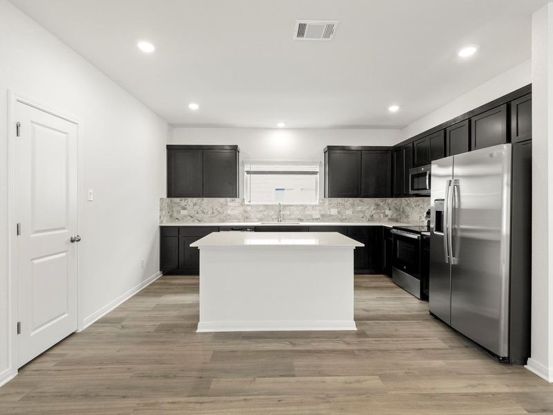 A well-appointed kitchen showcasing a central island and a full suite of modern appliances.