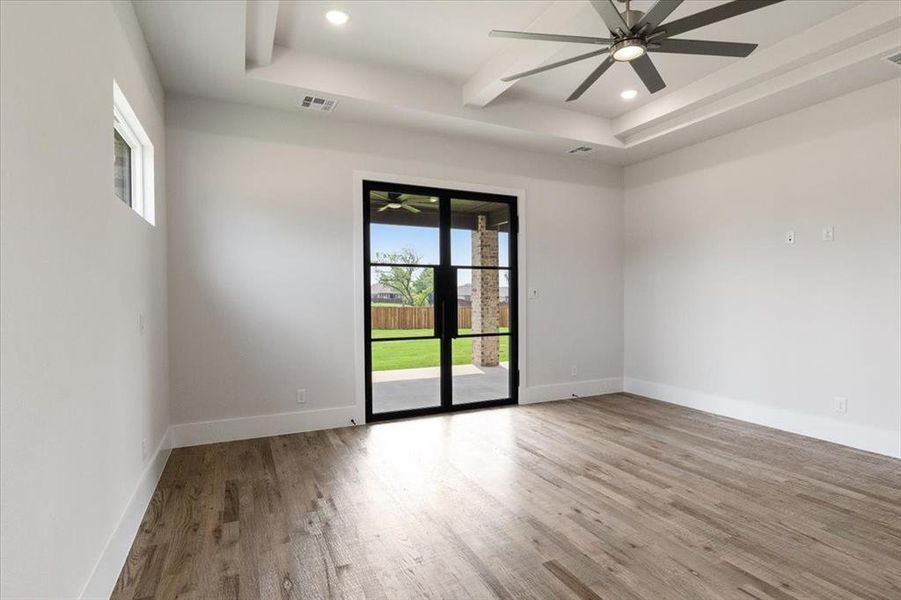 Spare room featuring a healthy amount of sunlight, light wood-type flooring, and ceiling fan