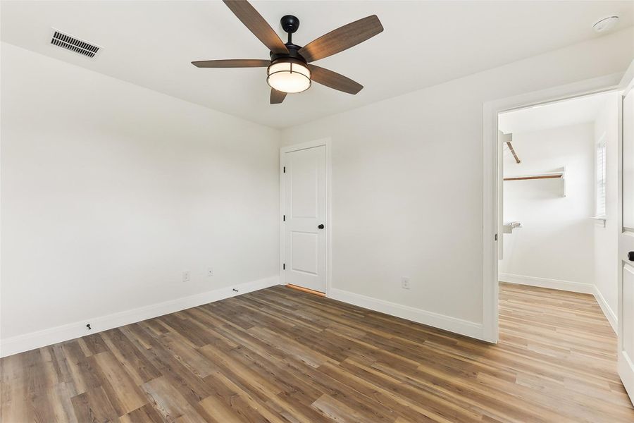 Bedroom 3 with baseboards, wood look floors, and visible vents Bedroom 3 with baseboards, wood look floors, and visible vents