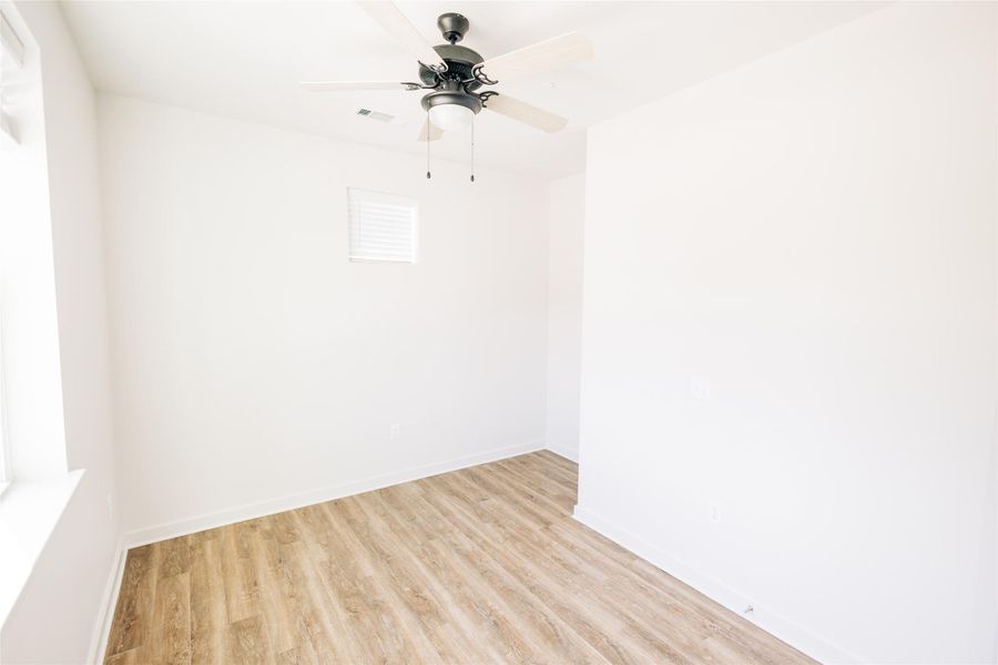 Unfurnished room with light wood-type flooring, baseboards, and a ceiling fan