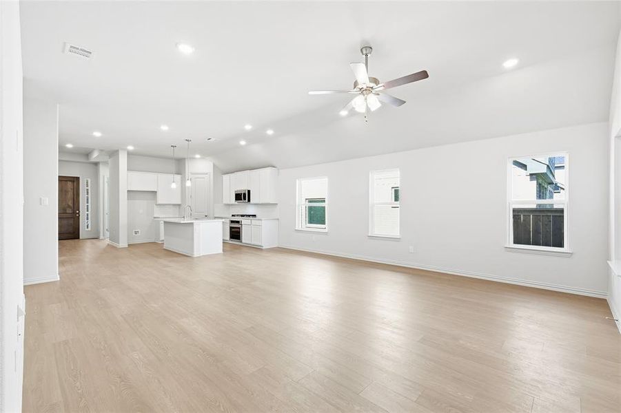Unfurnished living room with recessed lighting, vaulted ceiling, light wood-type flooring, and a ceiling fan