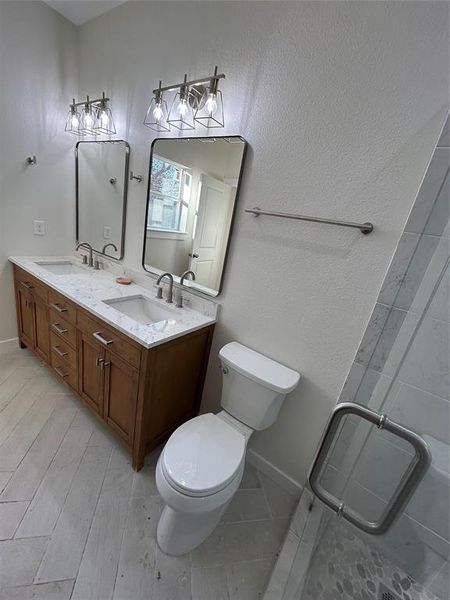 Master bathroom with vanity, toilet, and an enclosed shower