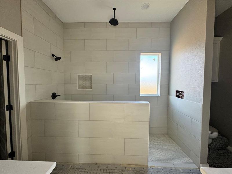 Bathroom featuring tiled shower and tile patterned floors