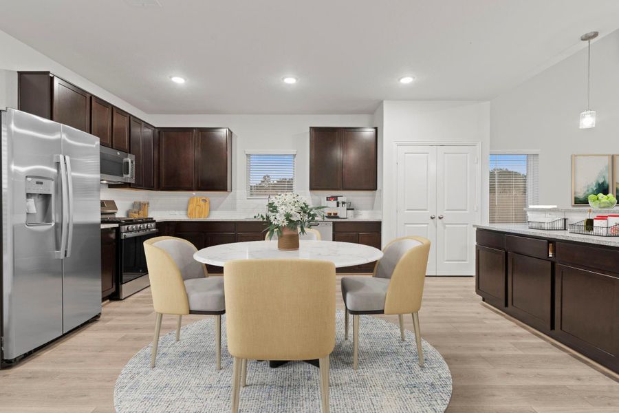 Another virtually staged angle showcases the kitchen’s thoughtful layout with ample storage, stainless steel side by side refrigerator, and generous countertop space. The blend of dark cabinetry and light finishes adds warmth and modern style.