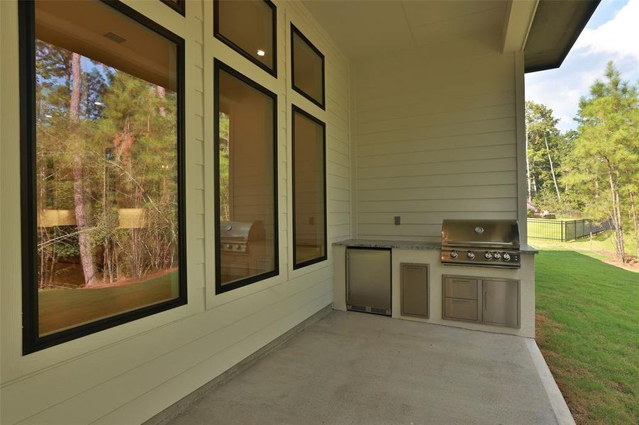 The outdoor kitchen with Blaze grill and fridge, a pull out garbage receptacle and storage drawers.