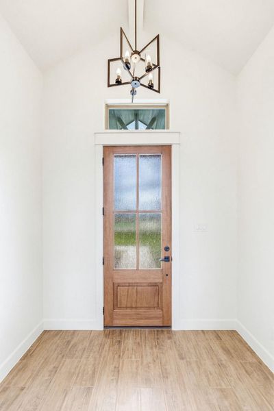 A striking glass-paned wooden entry door welcomes you to this modern space. A striking glass-paned wooden entry door welcomes you to this modern space.