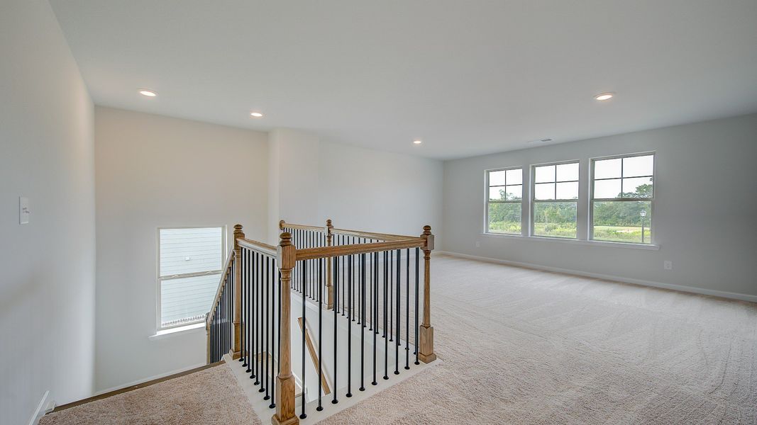 Stonefield open loft for versatile use with carpet flooring and natural light at Brighton in Locust Grove, GA.